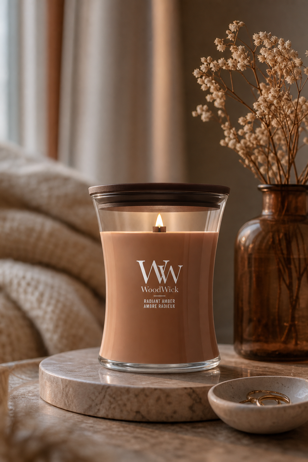 Brennende WoodWick Radiant Amber Kerze auf einem Tisch