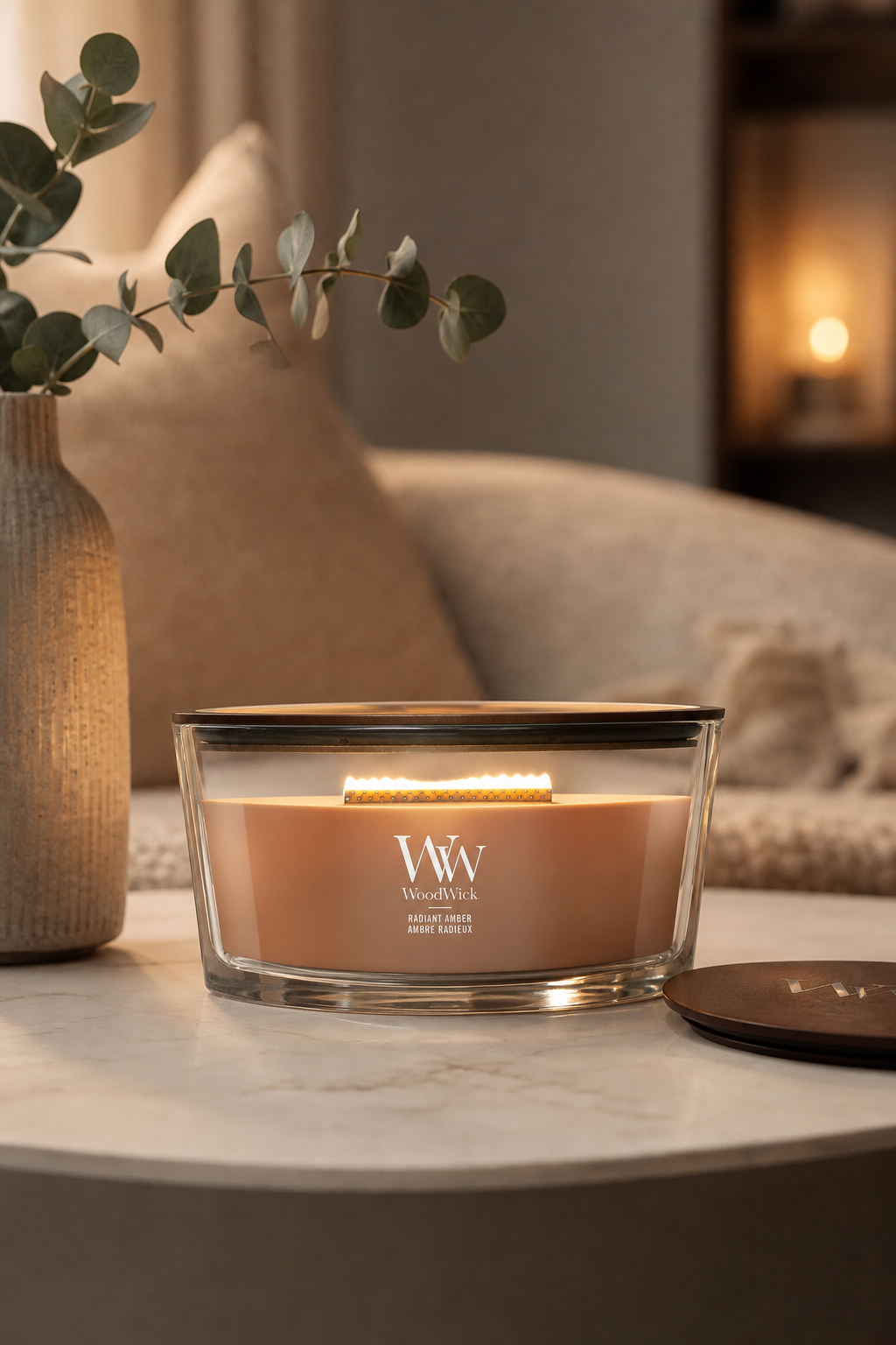 Brennende WoodWick Radiant Amber Kerze im Glas auf einem Wohnzimmertisch