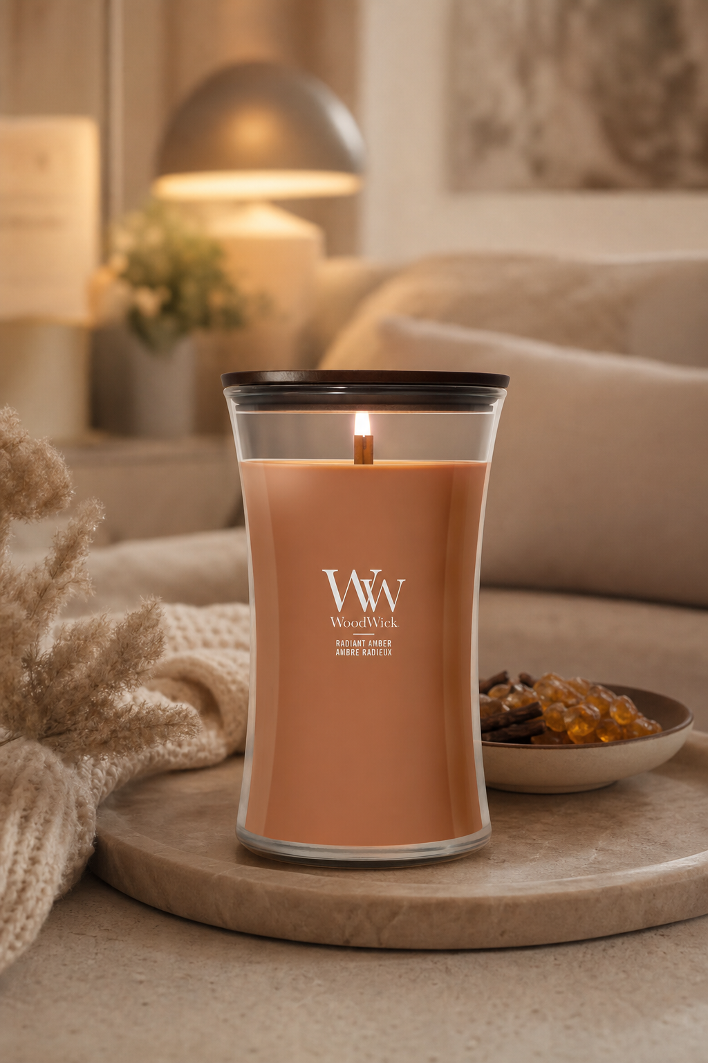 Brennende Radiant Amber Kerze von WoodWick auf einem Wohnzimmertisch