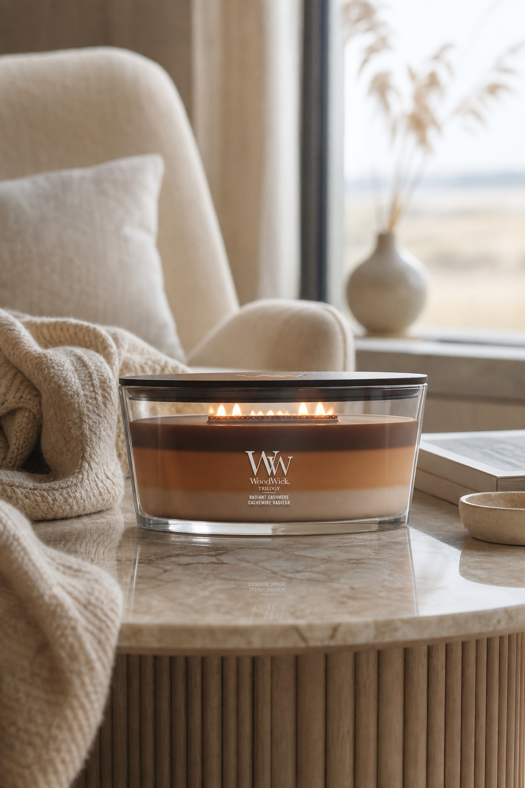 Brennende WoodWick Radiant Cashmere Trilogy-Kerze auf einem Tisch im Wohnbereich