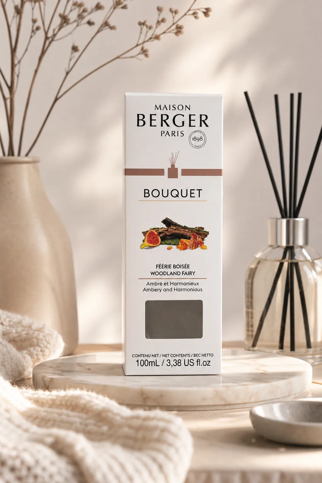 Raumduft-Verpackung neben Diffuser Maison Berger Raumduft-Verpackung neben einem Diffuser mit schwarzen Duftstäbchen