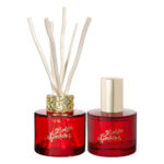 Roter Diffuser mit Duftstäbchen neben rotem Raumspray