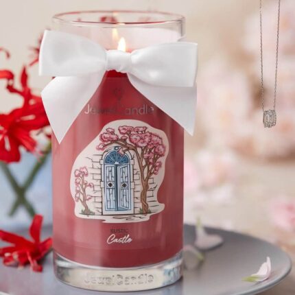 Rustic Castle Kerze mit Schleife und daneben hängender Schmuck-Halskette