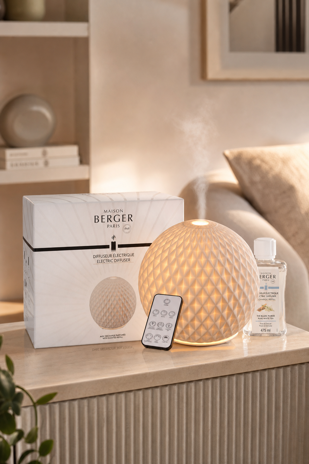 Beleuchteter Aroma-Diffuser mit Verpackung, Fernbedienung und Nachfüllflakon auf einem Tisch