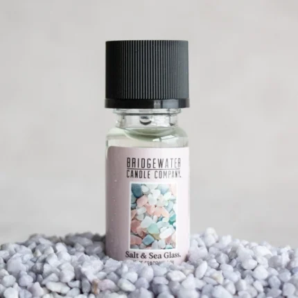 Salt & Sea Glass Duftölfläschchen steht auf hellen Dekosteinen