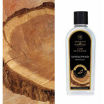 Flasche Ashleigh & Burwood Sandalwood Lamp Fragrance vor Holzscheibe