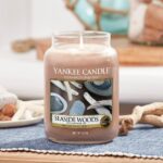 Brennende Yankee Candle Seaside Woods Kerze im Glas auf gedecktem Tisch