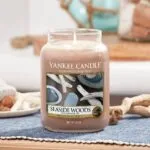 Brennende Yankee Candle Seaside Woods Kerze im Glas auf gedecktem Tisch