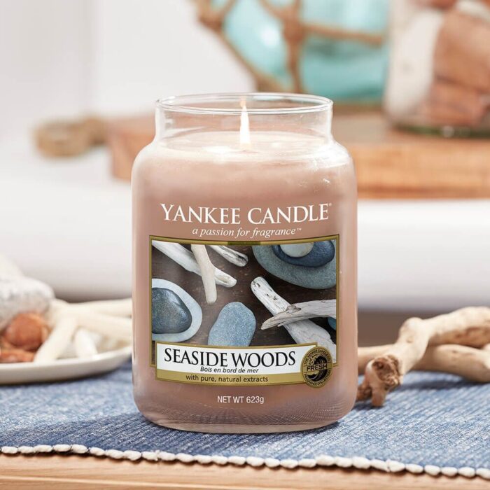 Brennende Yankee Candle Seaside Woods Kerze im Glas auf gedecktem Tisch