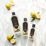 Drei Sicilian Lemon Lamp Fragrance Flaschen mit Zitronen auf hellem Untergrund