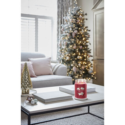 Brennende Letters to Santa Kerze steht auf Couchtisch vor Weihnachtsbaum