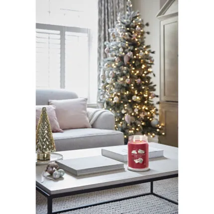 Brennende Letters to Santa Kerze steht auf Couchtisch vor Weihnachtsbaum