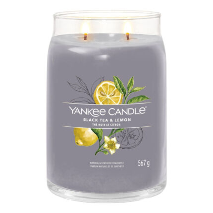 Zwei brennende Yankee Candle Black Tea & Lemon Kerzen auf einem Holzbrett