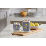 Zwei brennende Yankee Candle Black Tea & Lemon Kerzen neben einer Schale Zitronen