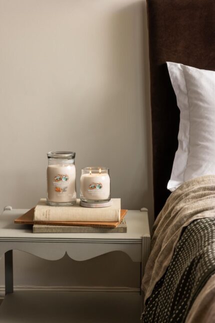 Yankee Candle Afternoon und brennende Kerze auf einem Bücherstapel neben dem Bett