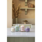 Vier Yankee Candle Gläser nebeneinander, darunter eine brennende rosa Desert Blooms Kerze