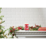Rote Yankee Candle Kerze zwischen Tannenzweigen und Weihnachtsbüchern