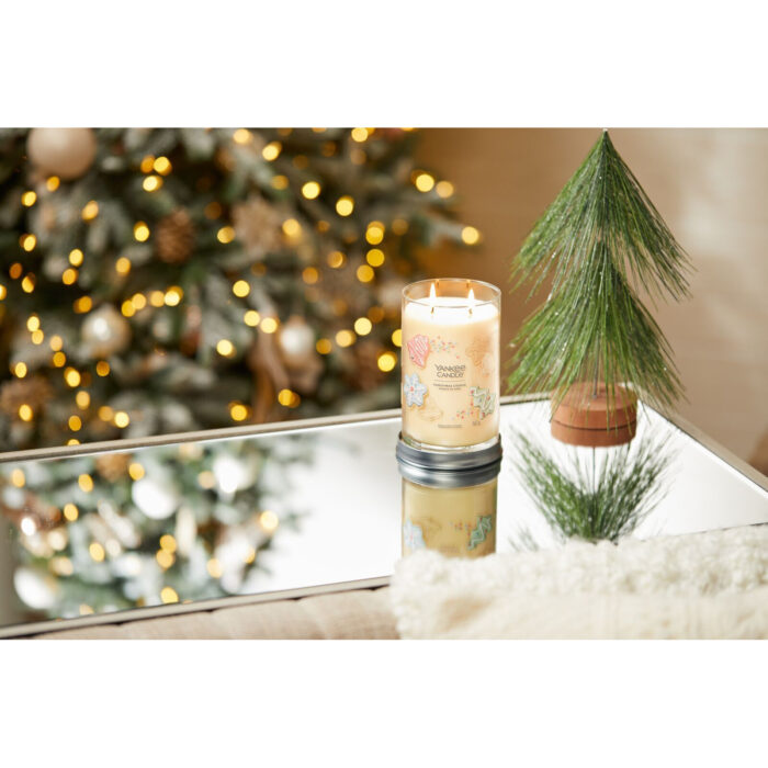 Brennende Christmas Cookie Kerze mit zwei Flammen vor Weihnachtsbaum