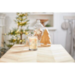 Brennende Christmas Cookie Kerze auf Holztisch mit Weihnachtsdekoration
