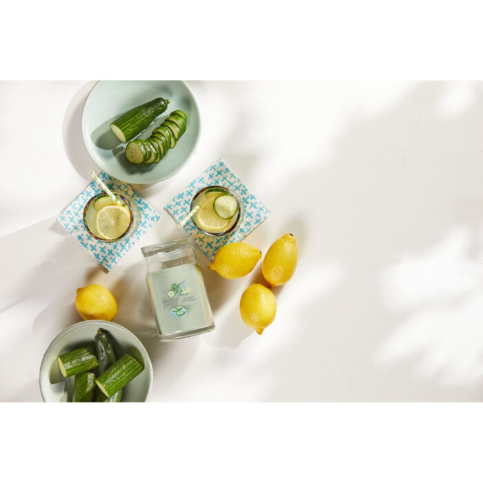 Cucumber Mint Cooler Kerze zwischen Gurken, Zitronen und Getränken