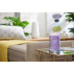 Brennende Lilac Blossoms Kerze auf einem Wohnzimmertisch neben einem Sofa
