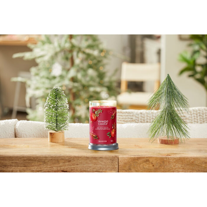 Red Apple Wreath Kerze auf einem Tisch zwischen Weihnachtsdekoration