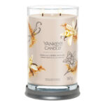 Geöffnete Yankee Candle mit zwei brennenden Dochten auf grauem Sockel