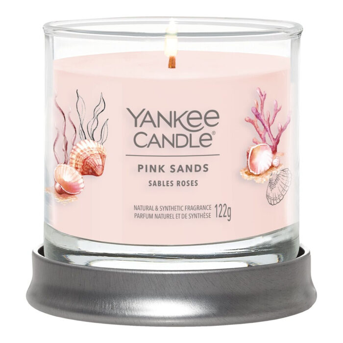 Brennende Pink Sands Duftkerze im Glas auf grauem Untersetzer