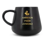 Schwarze Tassenkerze mit goldenem Slytherin-Symbol und Aufschrift Ambition Pride Cunning