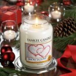 Brennende Snow In Love Kerze auf Glasschale in festlicher Dekoration