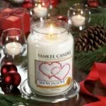 Brennende Snow In Love Kerze auf Glasschale in festlicher Dekoration