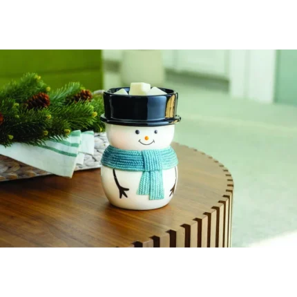 Schneemann-Duftlampe mit Duftwachswürfeln auf einem Holztisch neben Tannenzweigen