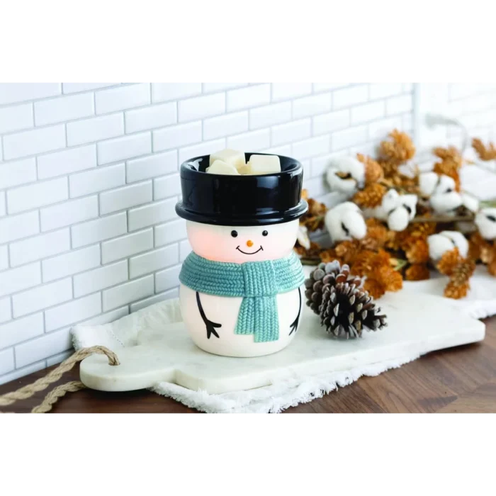 Schneemann-Duftlampe mit Duftwachswürfeln neben Tannenzapfen und Dekoration