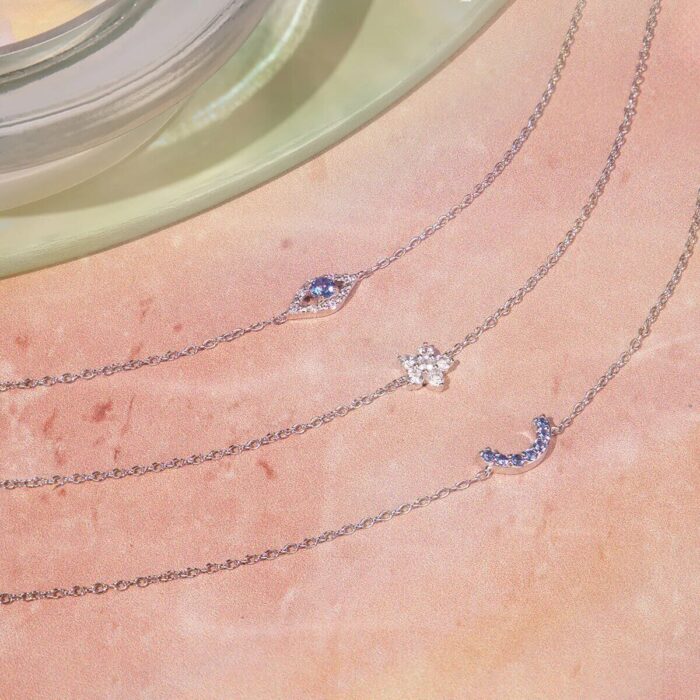 Drei filigrane Armbänder mit Mond-, Blumen- und bläulichem Anhänger