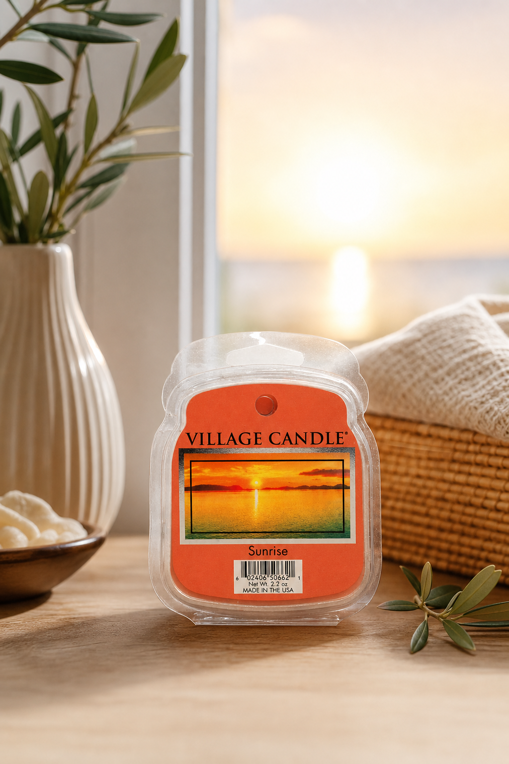 Village Candle Sunrise Kerze steht auf einem Holztisch vor einem Fenster