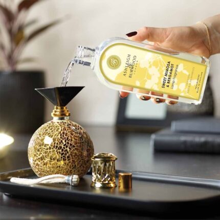 Sweet Mimosa & Bergamot Duftlampenöl wird in eine dekorative Duftlampe gegossen