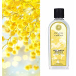 Flasche Sweet Mimosa & Bergamot Lamp Fragrance vor gelben Blüten