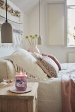 Brennende Yankee Candle Sweet Plum Sake Kerze auf einem Wohnzimmertisch