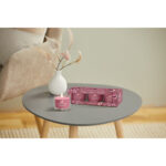 Yankee Candle Sweet Plum Sake Packung und angezündete Votivkerze auf Tisch