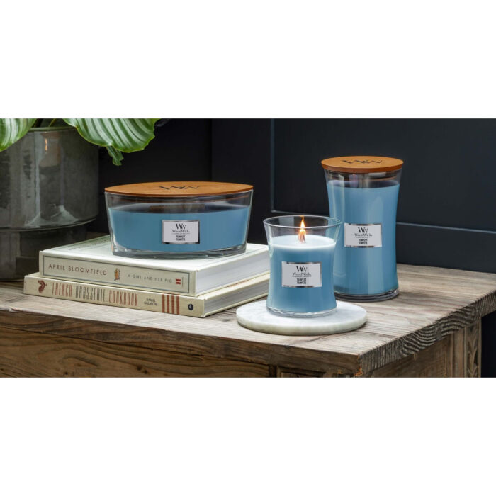 Brennende WoodWick Tempest Kerze auf einem Tisch vor Meeresblick