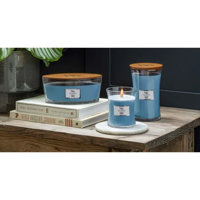 Brennende WoodWick Tempest Kerze auf einem Tisch vor Meeresblick