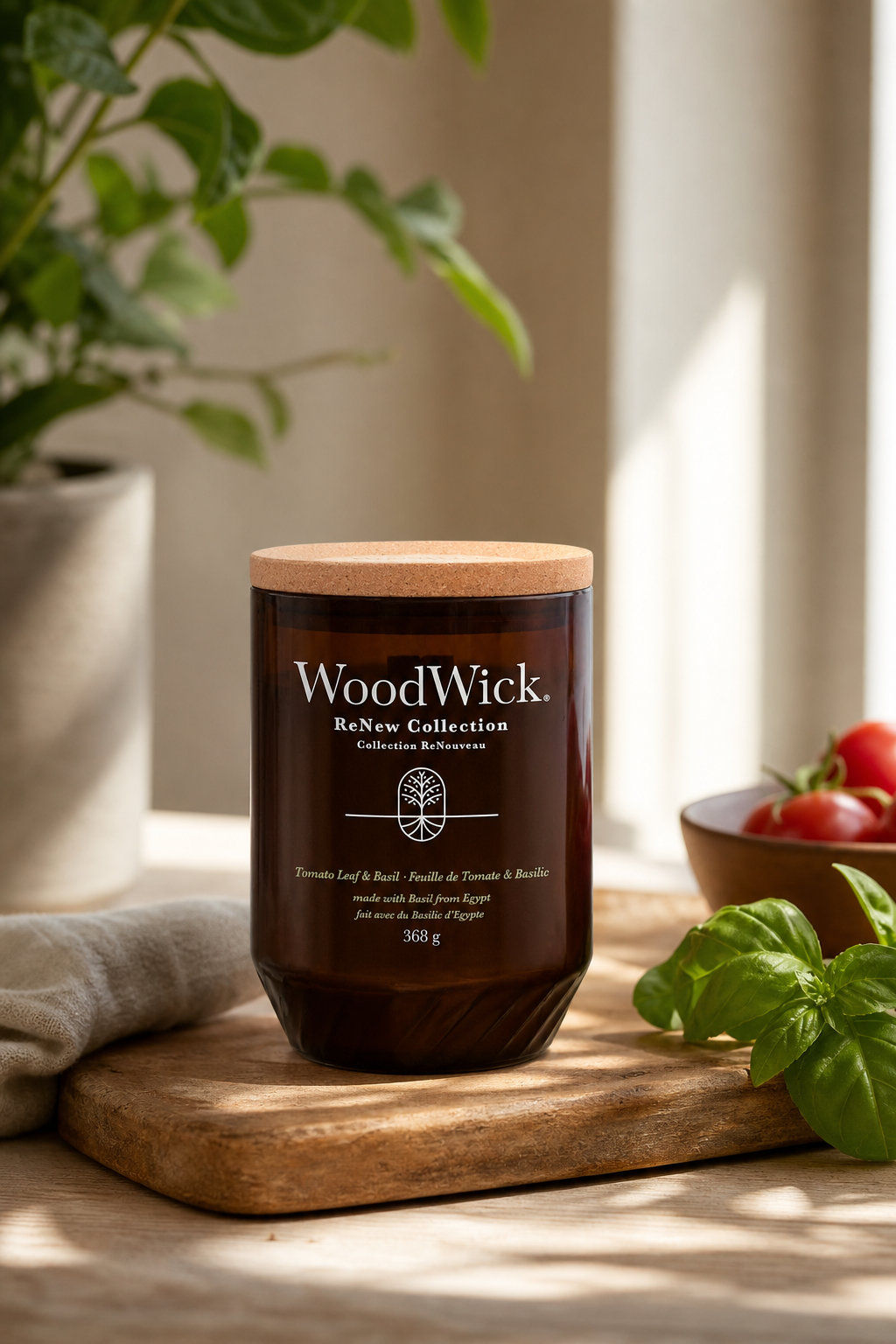 WoodWick Tomato Leaf & Basil Kerze auf Holzbrett neben Tomaten und Basilikum