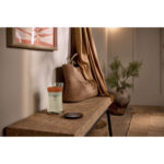 Brennende WoodWick Trilogy Vanilla Embers Kerze mit Deckel daneben