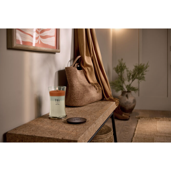 Brennende WoodWick Trilogy Vanilla Embers Kerze mit Deckel daneben