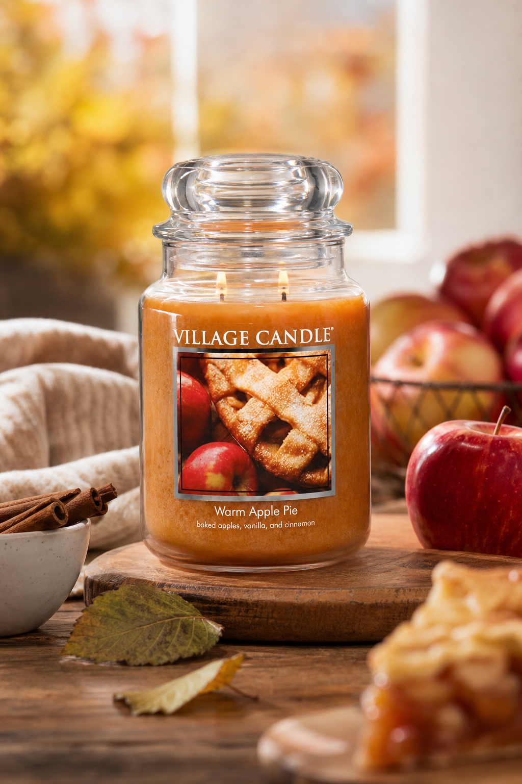 Brennende Warm Apple Pie Kerze im Glas auf Holztisch mit Äpfeln