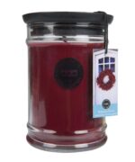 Rote Kerze im Glas mit schwarzem Deckel und Welcome-Home-Anhängeetikett