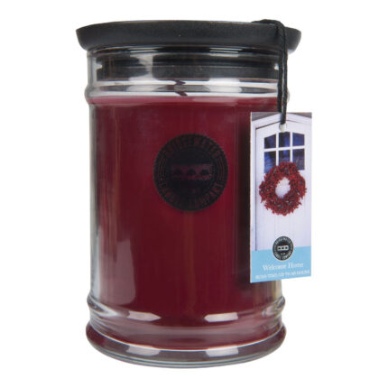 Rote Welcome Home Kerze im Glas mit schwarzem Deckel und Anhängeetikett