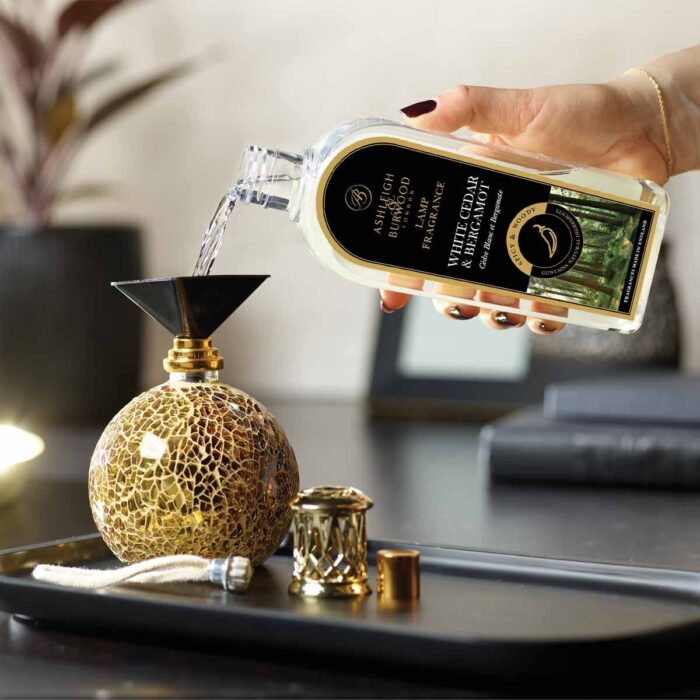 Hand gießt White Cedar & Bergamot Lamp Fragrance in eine Duftlampe