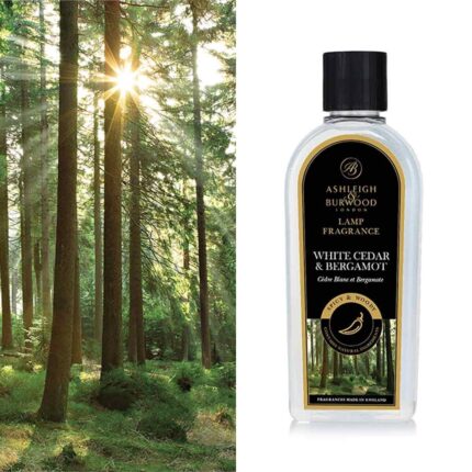 Flasche mit White Cedar & Bergamot Lamp Fragrance vor einem Nadelwald