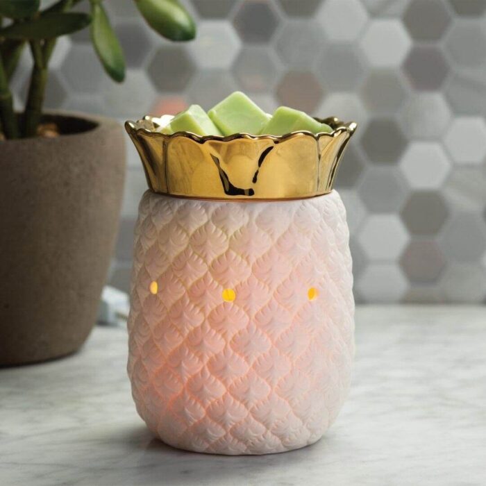 Weiße Ananas-Duftlampe mit grünlichen Wachswürfeln auf einer Fläche